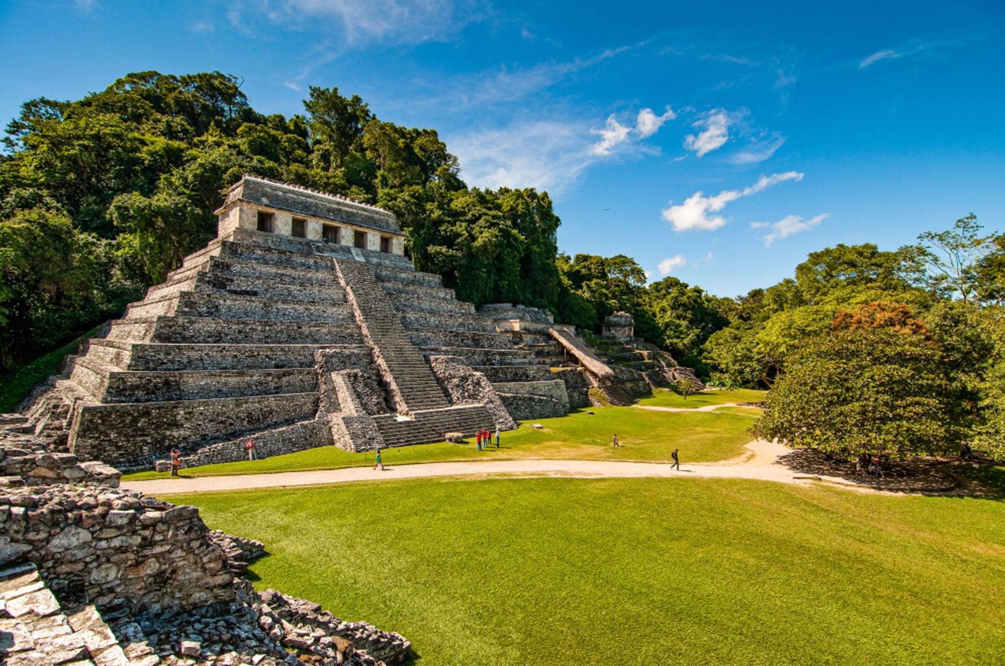 Maya-tempel El Castillo in Palenque, Mexico, omringd door jungle en een groene vlakte.