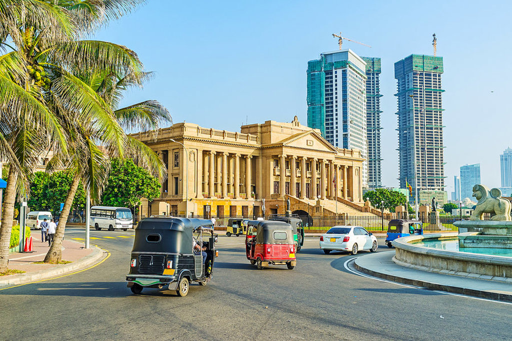 Tuk-tuks rijden langs het oude parlementsgebouw in Colombo, Sri Lanka.