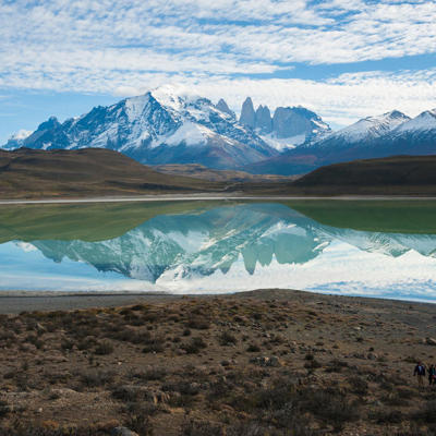 Azuurblauw meer met spiegeling van besneeuwde bergtoppen in Patagonië tijdens groepsrondreis.