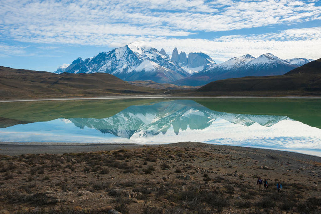 Azuurblauw meer met spiegeling van besneeuwde bergtoppen in Patagonië tijdens groepsrondreis.