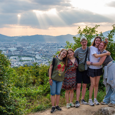 Gezin op uitzichtpunt met panorama over Kyoto tijdens familiereis Japan.