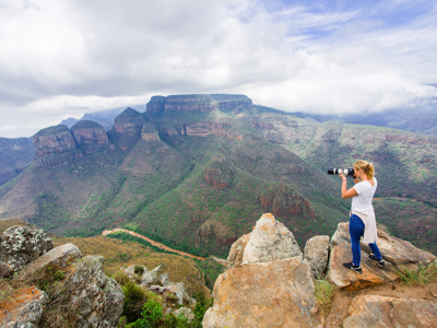 Fotograaf bij uitzichtpunt over de Blyde River Canyon en de Three Rondavels in Zuid-Afrika.