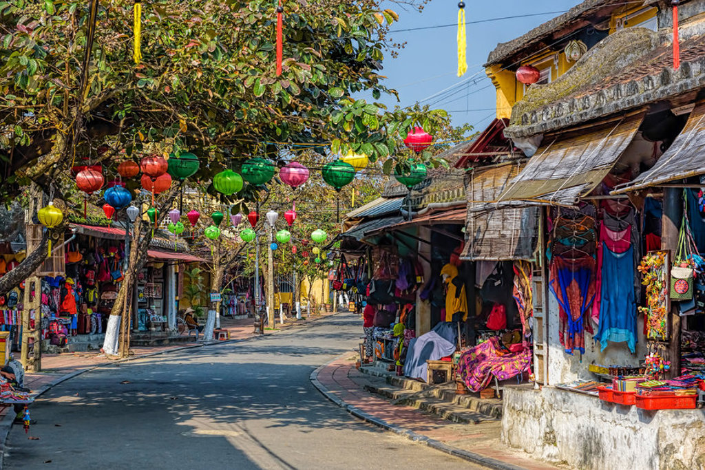 Sfeervolle straat in Hoi An, Vietnam met kleurrijke lampionnen en marktstalletjes tijdens een 22-35ers reis.