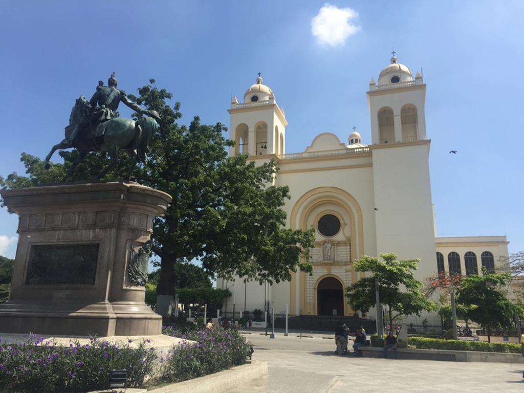 Standbeeld op plein met kathedraal in de achtergrond tijdens 22-35ers reis Guatemala, Honduras en El Salvador.