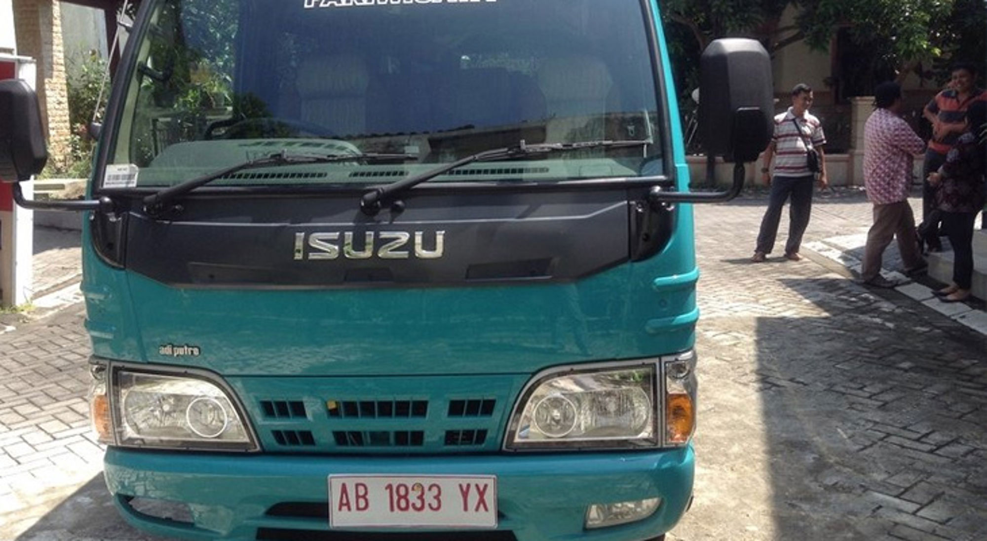 Borobodur vervoer Indonesië Turquoise Isuzu-busje met kenteken AB 1833 YX op straat in Indonesië.