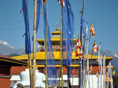 Boeddhistisch klooster met kleurrijke gebedsvlaggen en Himalaya-bergen op de achtergrond, route Sikkim en Bhutan.