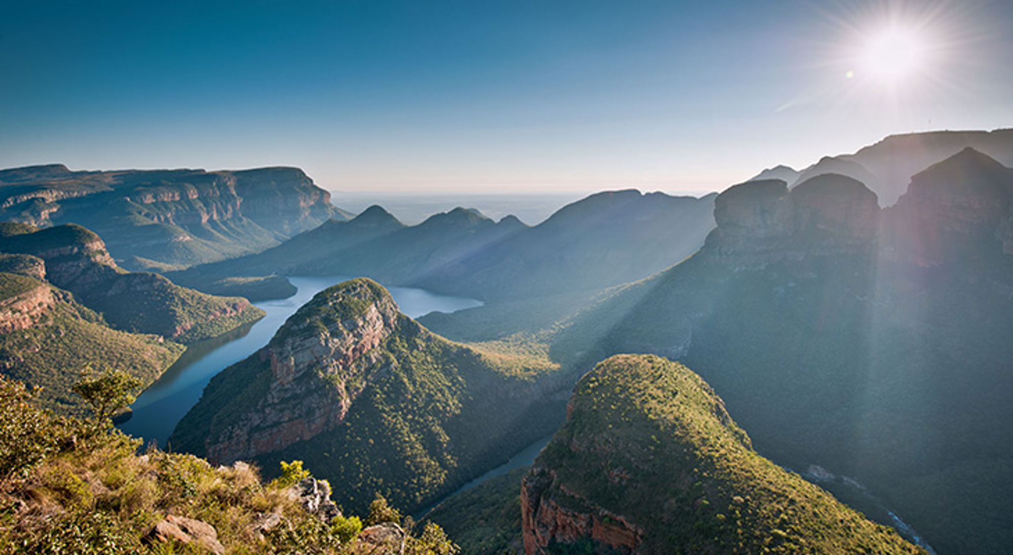 Blyde River Canyon bij Panorama Route Panorama van de Blyde River Canyon met kronkelende rivier en bergen in Zuid-Afrika bij zonlicht.