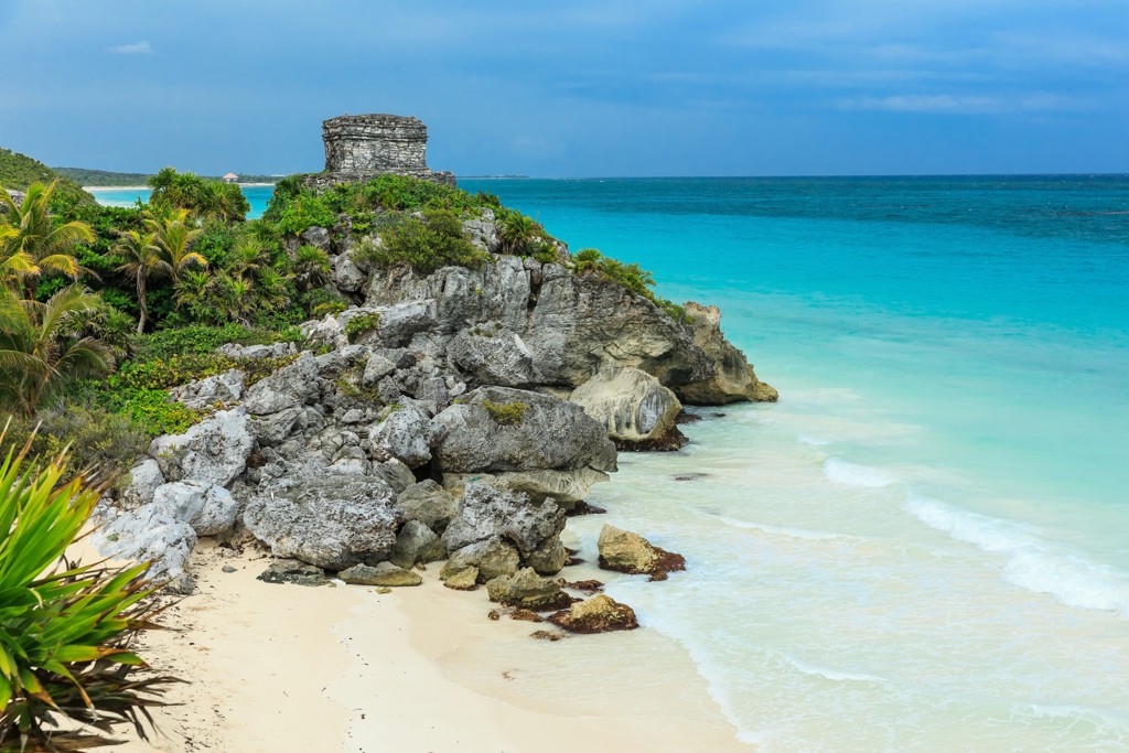Maya-ruïne van Tulum op een rots aan zee, met wit zandstrand en turquoise water in Mexico.