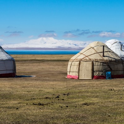 Yurts op de steppe bij een bergmeer in Kirgistan tijdens groepsrondreis wandelen langs de Zijderoute.