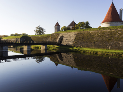 Kuressaare kasteel op Saaremaa met houten brug en weerspiegeling in het water, Route Baltische Staten.