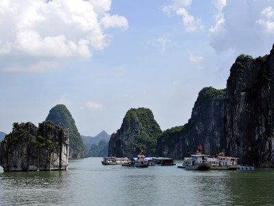 Cruiseboten tussen kalkstenen karstbergen in Halong Bay, Vietnam.
