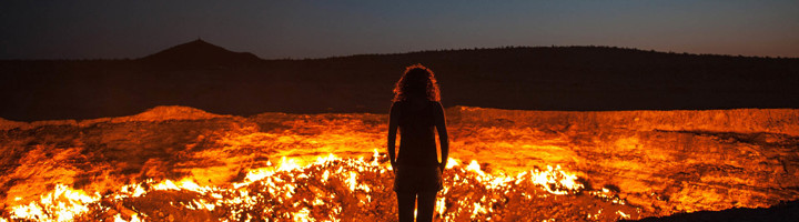 Reiziger bij de brandende Darvaza-gaskrater in Turkmenistan tijdens een groepsrondreis.