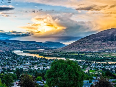 Uitzicht over Kamloops met de Thompson River en bergen bij zonsondergang tijdens Route Canada.