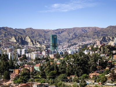 Panorama van La Paz met de groene Torre Ejecutiva en de Andesbergen op de achtergrond.