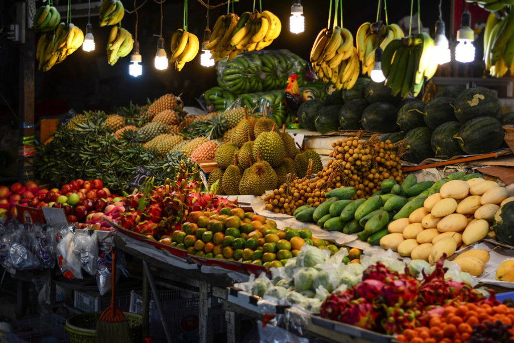 Fruitkraam op lokale markt met bananen, ananas, mango’s en watermeloenen tijdens groepsrondreis Singapore, Maleisië & Thailand.