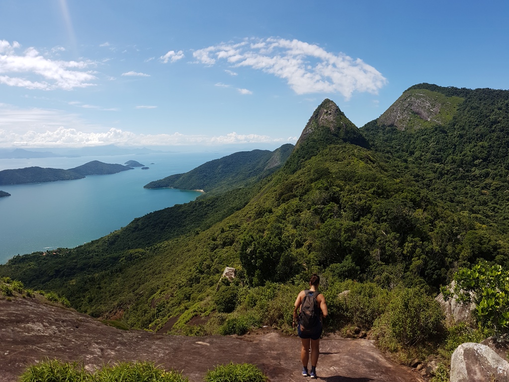 Uitzicht vanaf een wandelpad op groene bergen en de kust bij Paraty, Brazilië.