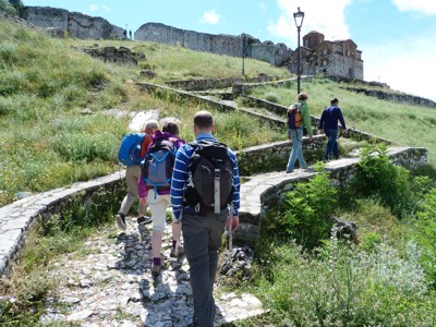 Wandelaars op een stenen pad naar het kasteel van Berat tijdens de Route Albanië.