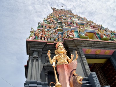 Kleurrijke hindoetempel in Sri Lanka met beeld van godheid en rijk versierde toren.