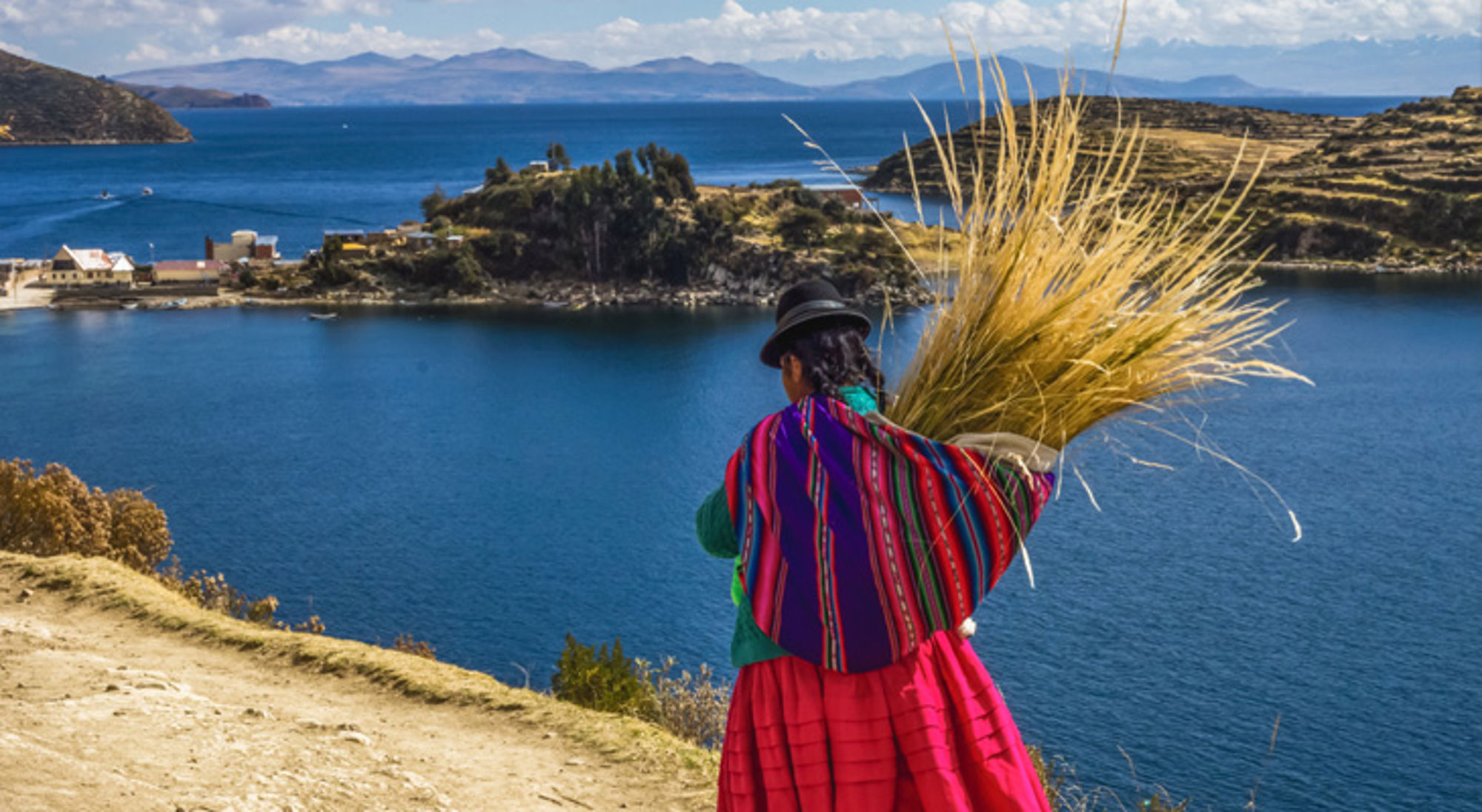Titicacameer Bolivia Vrouw in traditionele kleding met rietbundel op de oever van het Titicacameer in Bolivia.