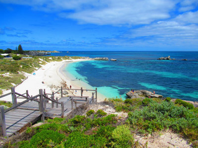 Houten vlonderpad naar wit zandstrand en turquoise zee aan de kust van West-Australië.