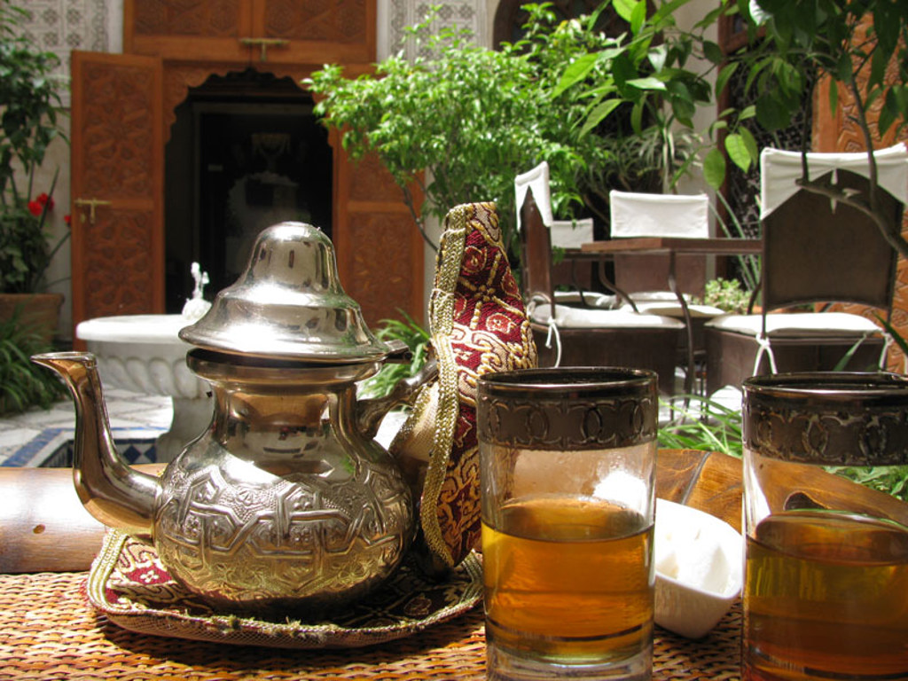 Marokkaanse muntthee met zilveren theepot op tafel in een riad, tijdens groepsrondreis Marokko hoogtepunten.