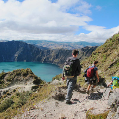 Wandelaars dalen af langs de Quilotoa-krater met uitzicht op het turquoise kratermeer in Ecuador.