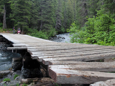 Houten brug over een rivier in het bos tijdens de Route Alaska.