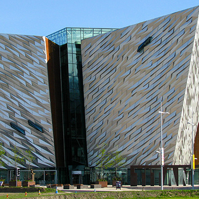Moderne gevel van het Titanic Museum Belfast met zilverkleurige panelen en glazen entree.