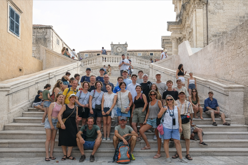 Groepsfoto van reizigers op de trappen van de Jezuïetenkerk in Dubrovnik tijdens familiereis Kroatië en Montenegro.