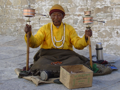 Tibetaanse monnik met gebedsmolens bij een klooster tijdens de groepsrondreis Tibet en Nepal.