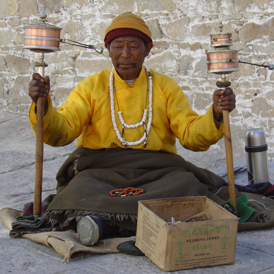 Tibetaanse monnik met gebedsmolens bij een klooster tijdens de groepsrondreis Tibet en Nepal.