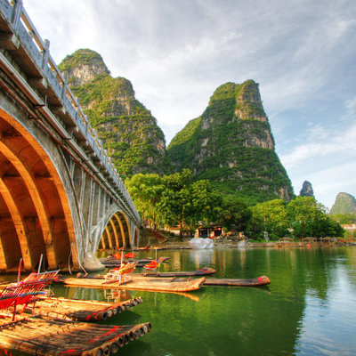 Bamboevlotten op de Li-rivier bij Guilin, met karstbergen en een boogbrug tijdens de groepsrondreis China.