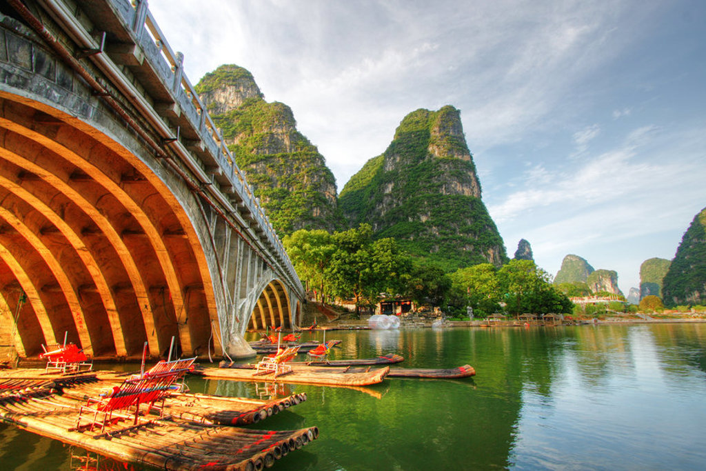Bamboevlotten op de Li-rivier bij Guilin, met karstbergen en een boogbrug tijdens de groepsrondreis China.