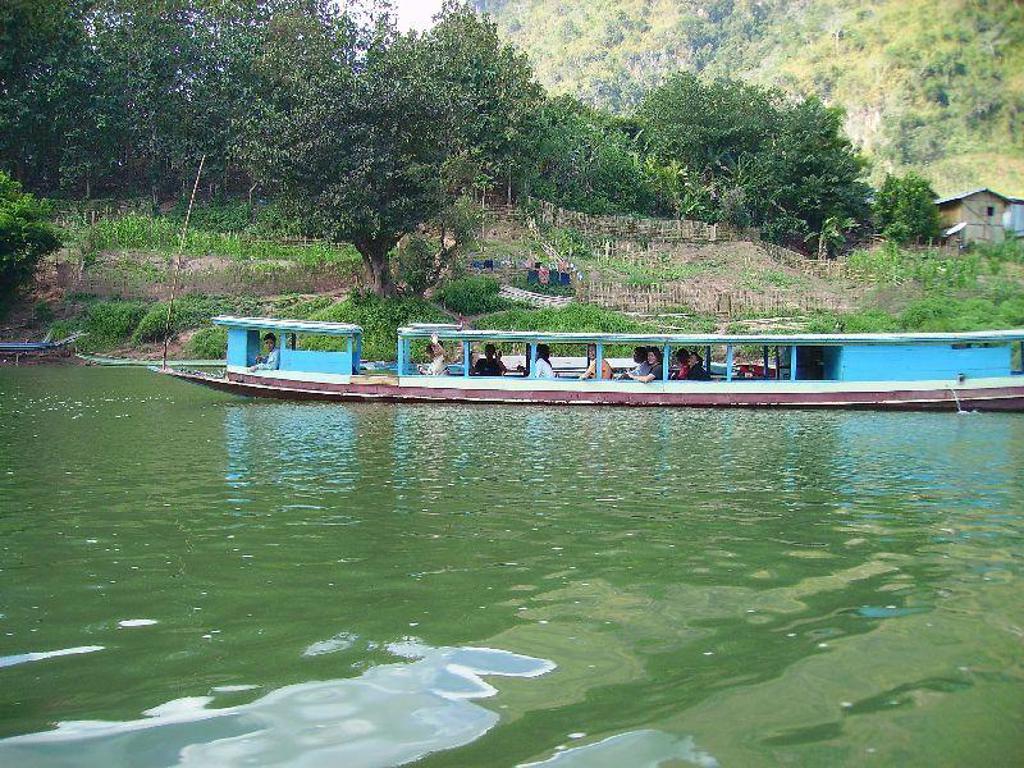 Boottocht over de Mekong langs groene oevers tijdens groepsrondreis Laos & Cambodja.