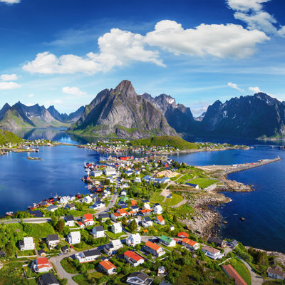 Uitzicht op een dorp aan de fjord met bergen op de Lofoten in Noorwegen tijdens een groepsrondreis.