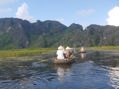 Boottocht door de Ninh Binh-rivier met kalksteenbergen op de achtergrond, Route Vietnam 17 dagen.