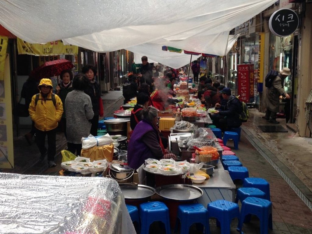 Traditionele markt in Zuid-Korea met kraampjes en fietsen onder een overkapping.