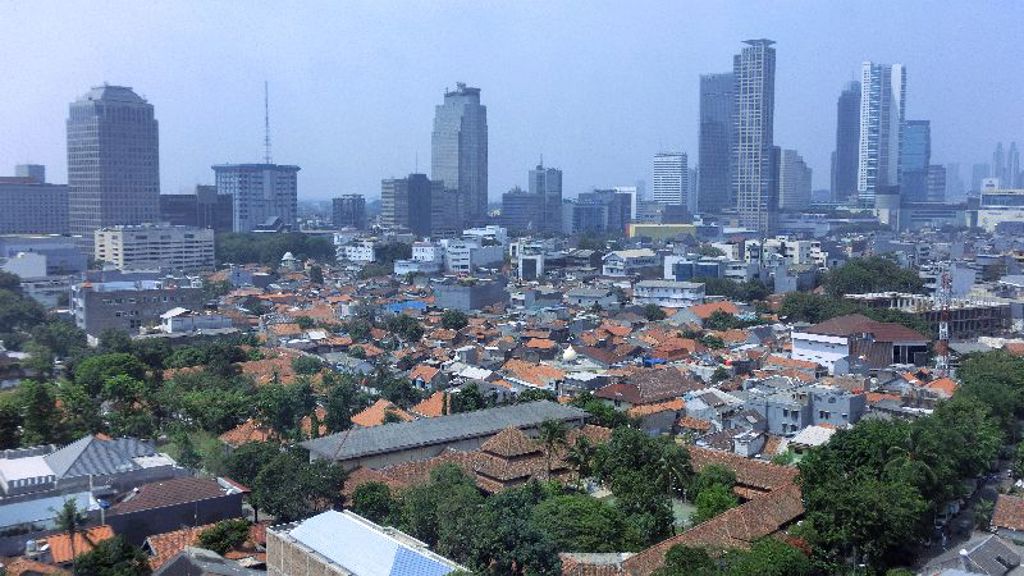 Skyline van Jakarta met wolkenkrabbers en woonwijken met rode daken tijdens de groepsrondreis Java & Bali.