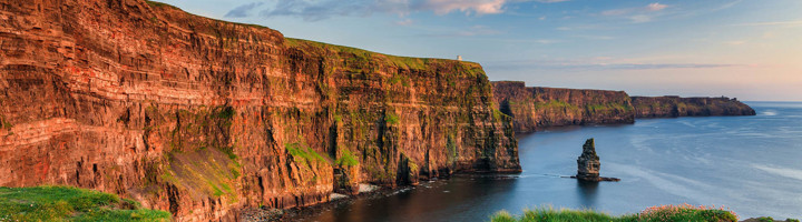 Kliffen van Moher aan de Ierse westkust bij zonsondergang, met steile rotswanden en uitzicht over de Atlantische Oceaan.
