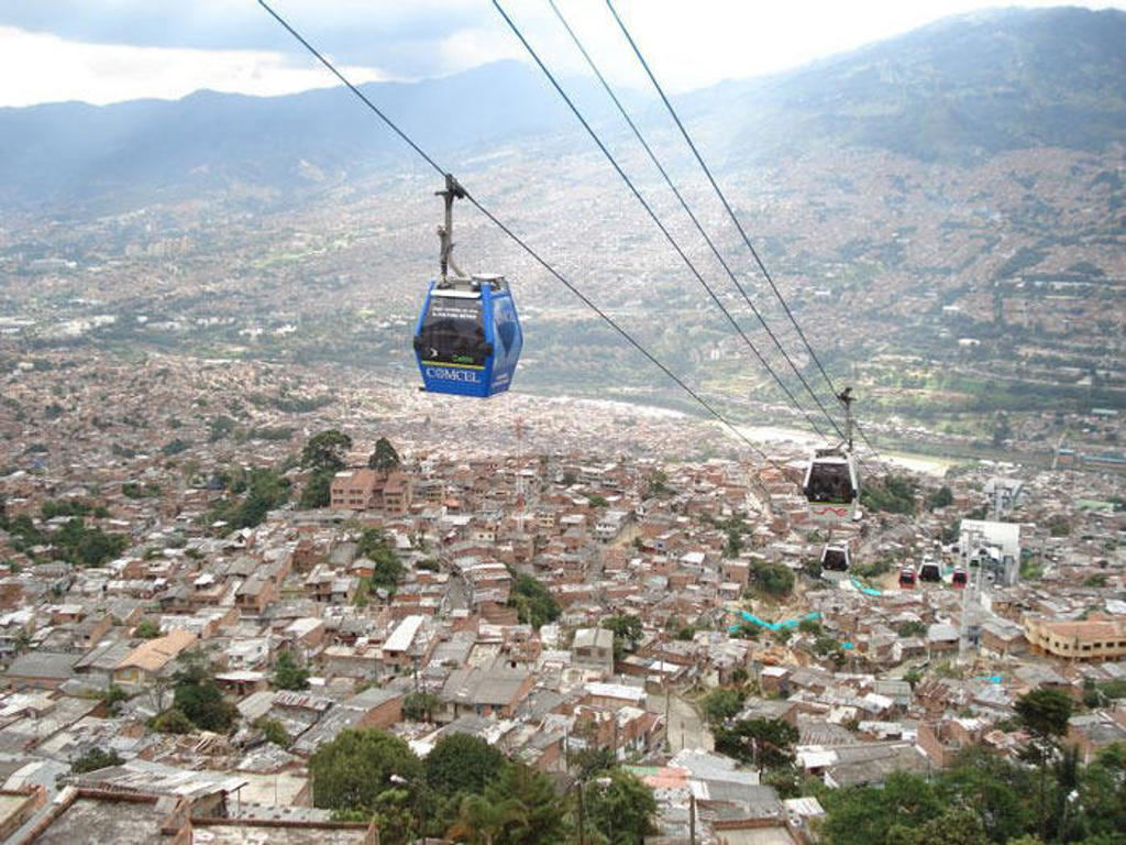 Kabelbaan Metrocable boven Medellín met uitzicht op de stad en omliggende bergen in Colombia.