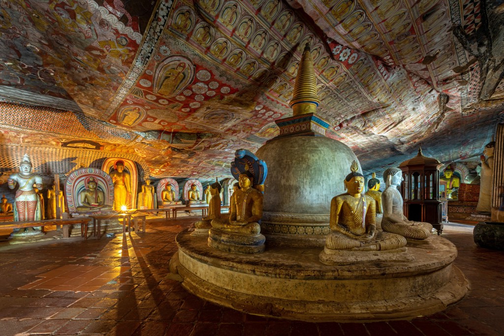 Boeddhabeelden en kleurrijke plafondschilderingen in de Dambulla-grottempel tijdens een 22-35ers reis Sri Lanka.