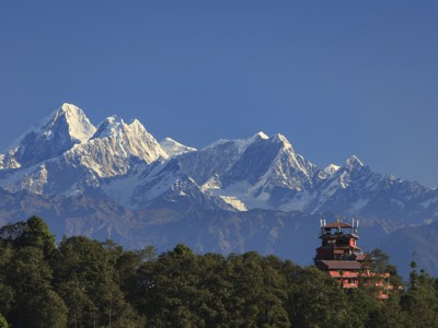 Sneeuwtoppen van de Himalaya met een tempel op een beboste heuvel in Nepal.