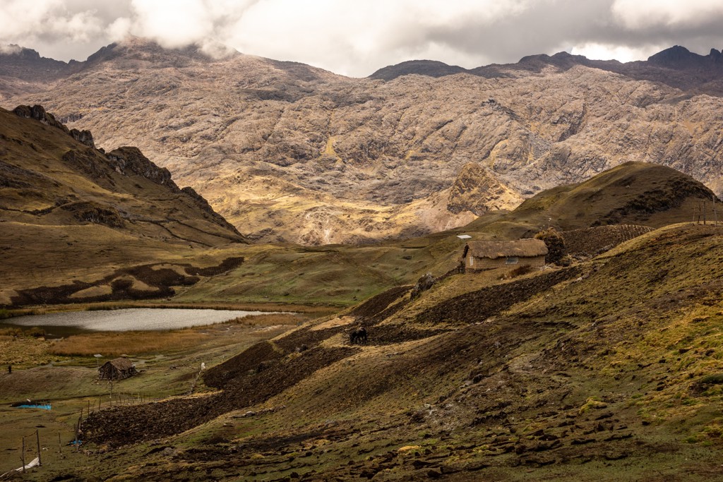 Berglandschap in Peru met hooglandmeer en traditionele hutten, gezien tijdens een groepsrondreis.