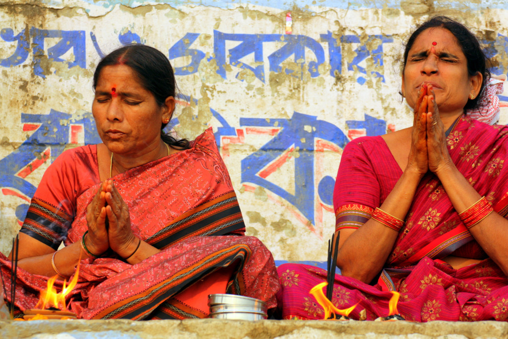 Vrouwen in kleurrijke sari’s bidden bij een ritueel vuur tijdens een groepsrondreis Noord-India en Nepal.