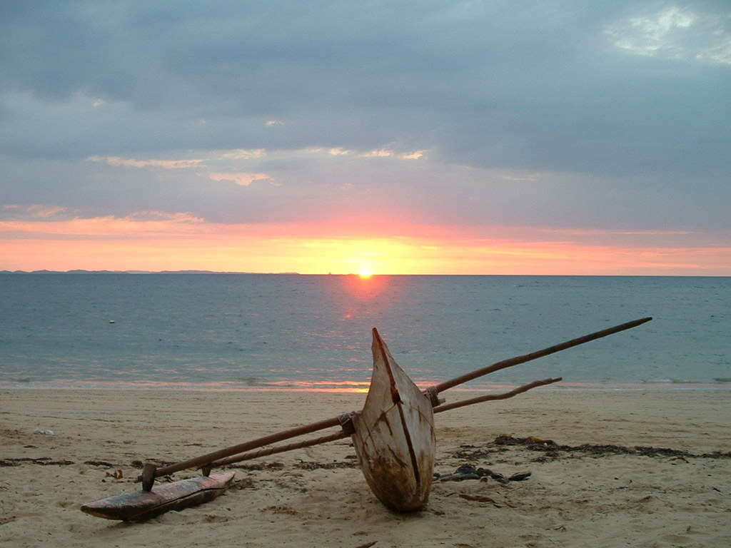 Traditionele pirogue op het strand bij zonsondergang in Madagascar tijdens een groepsrondreis.
