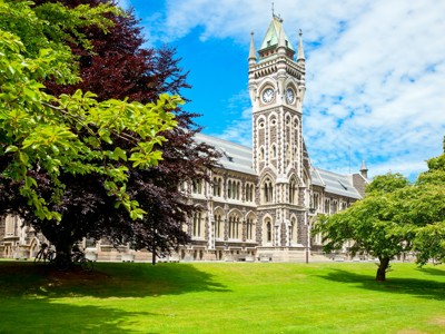Historisch gebouw met klokkentoren op de campus van de Universiteit van Otago in Dunedin, Route Nieuw-Zeeland.