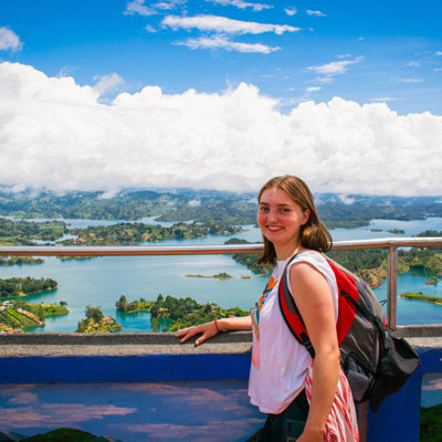 Reiziger op uitzichtpunt met panorama over het Guatapé-reservoir bij Medellín, tijdens 22-35ers reis Colombia.