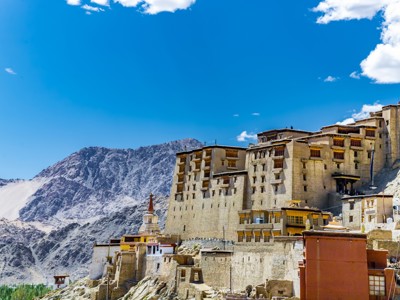 Thiksey-klooster in Ladakh, hoog op een heuvel met berglandschap onder een helderblauwe lucht.