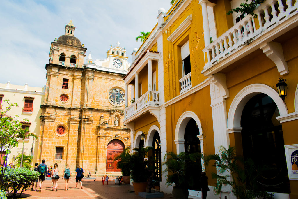 Kleurrijke straat in Cartagena, Colombia, met historische kerk en koloniale gebouwen tijdens een 22-35ers reis.