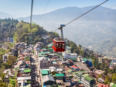 Rode kabelbaan boven Gangtok in Sikkim, met uitzicht op de stad en de Himalaya.